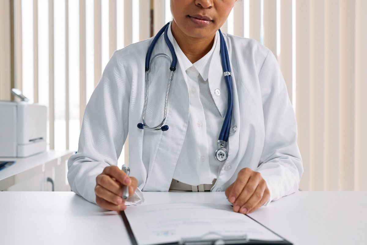 Black female doctor recording patient details